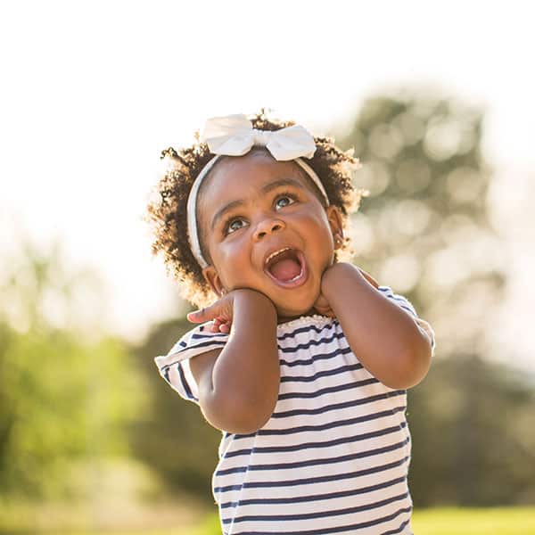 ToddlerSmilingOutside Young Girl Smiling Outdoors looking at the sky
