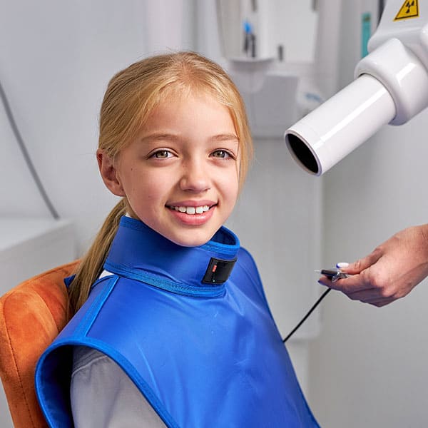 GirlReceivingDigitalXRays Girl receiving a digital x-ray at the dental office.